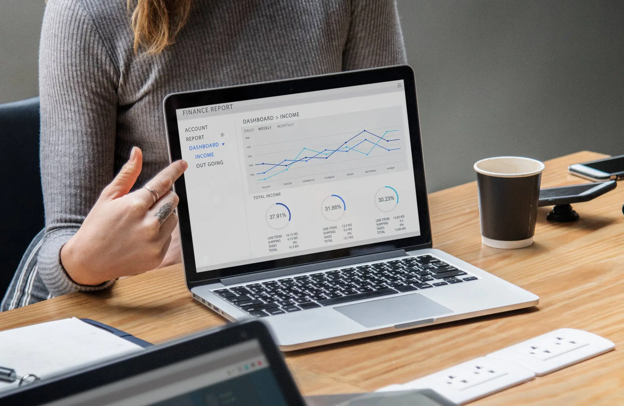 Person presenting a financial analytics dashboard on a laptop.
